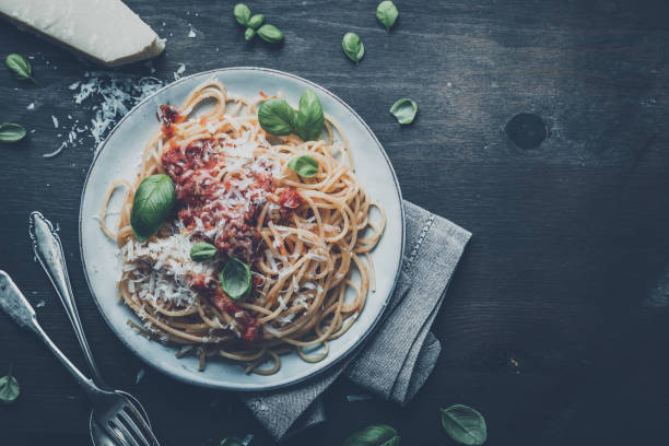 istock delicious appetizing classic spaghetti pasta with tomato sauce, parmesan cheese and fresh basil, top view 1128916007