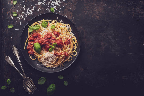 istock delicious appetizing classic spaghetti pasta with tomato sauce, parmesan cheese and fresh basil, top view 1128916026