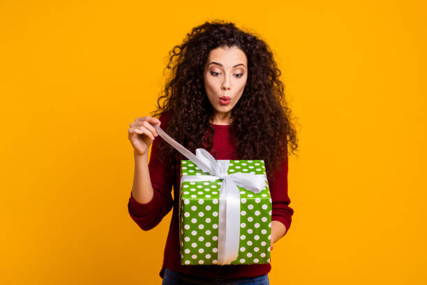 Close up photo beautiful cheerful amazing her she lady holding large package amazed expression desire wish what inside wearing red knitted sweater pullover clothes outfit isolated yellow background Close up photo beautiful cheerful amazing her she lady holding large package amazed expression desire wish what inside wearing red knitted sweater pullover clothes outfit isolated yellow background unwrapping stock pictures, royalty-free photos & images