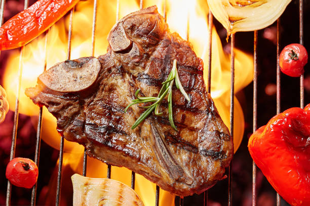 T-Bon steak grilled with vegetables. Fried meat on the fire, barbecue stock photo