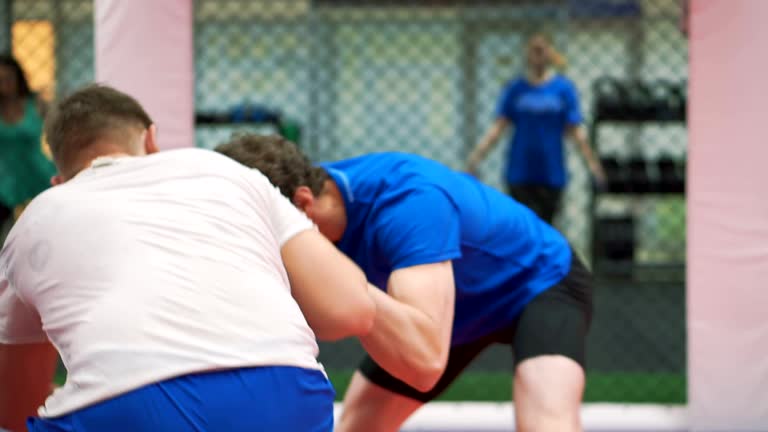 two wrestlers Greco-Roman wrestling on the gym.