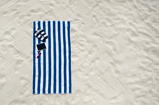 Vista superior de la playa con toalla marco y verano accesorios. Fondo con copia espacio y textura arena visible. photo