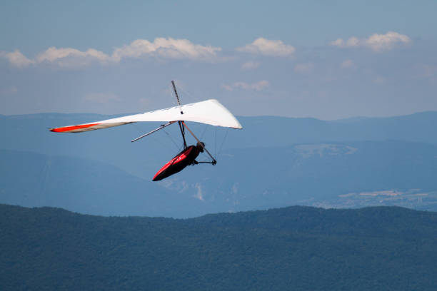 istock Man Hand-gliding over Mointains on a Hot Summer Day 1128920214