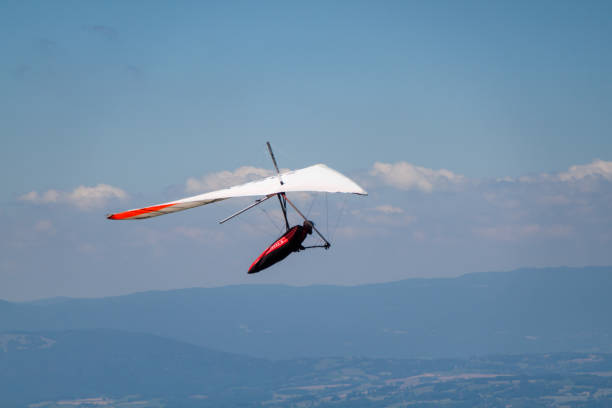 istock Man Hand-gliding over Mointains on a Hot Summer Day 1128920537