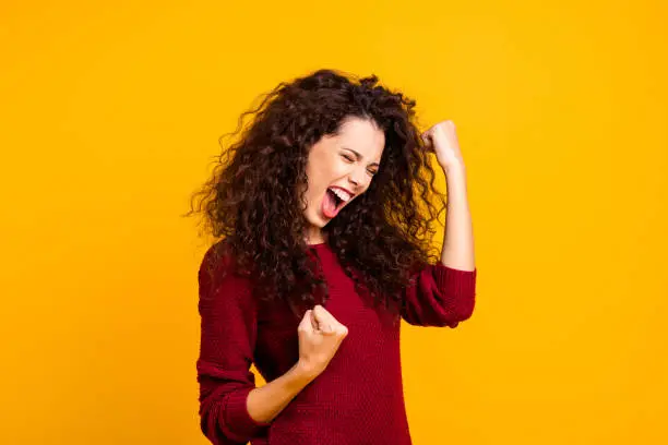 Close up photo amazing beautiful her she lady yelling voice raised fists eyes closed in delight emotional high spirits mood wearing red knitted sweater clothes outfit isolated yellow background