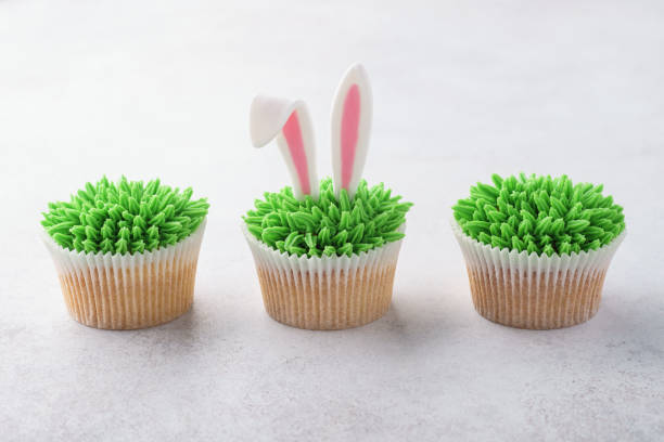 istock Row of Easter cupcakes decorated with grass and bunny ears. 1128922191
