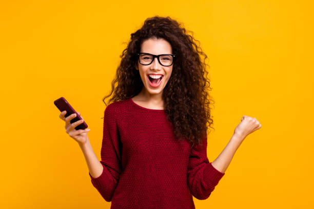 porträt ihrer she schön niedlich schöne attraktive ziemlich fröhlich erstaunt gewellten haaren dame hält in händen zelle unglaubliche omg cool große helle lebhaften glanz orange hintergrund isoliert - hairstyle art young adult beautiful people stock-fotos und bilder