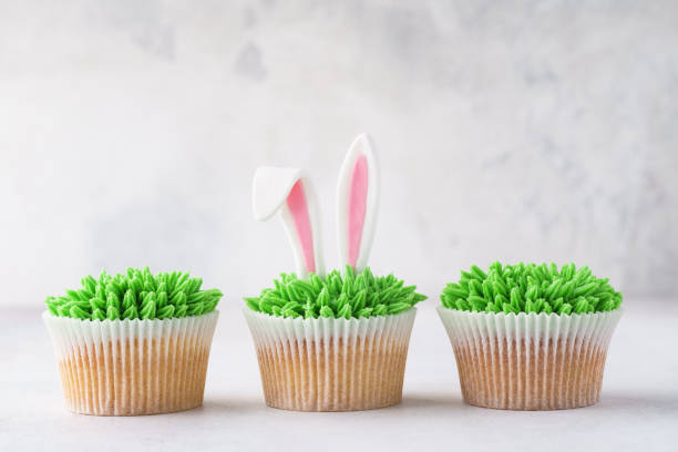 istock Row of Easter cupcakes decorated with grass and bunny ears. 1128922672
