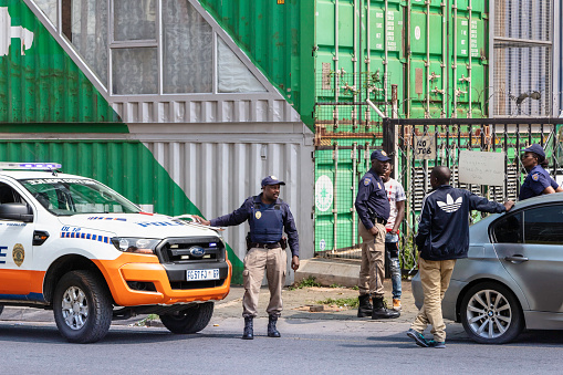 Police officers issuing a traffic fine to a road offender in Maboneng, Johannesburg.  Maboneng meaning 'a place of light' is a precinct of Johannesburg city and regeneration development in the city centre attracting new business, arts and culture.