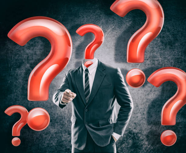 istock Question mark as head on businessman in a suit pointing at you 1128924941