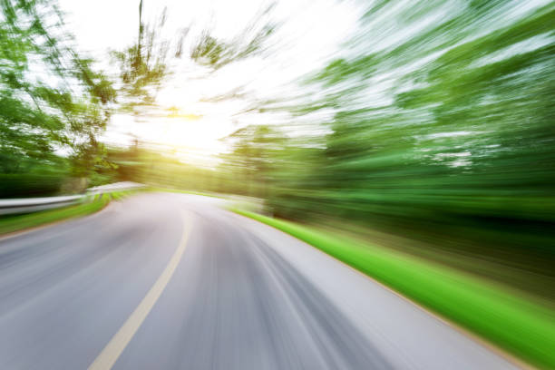 istock Motion blurred road in green forest 1128925063