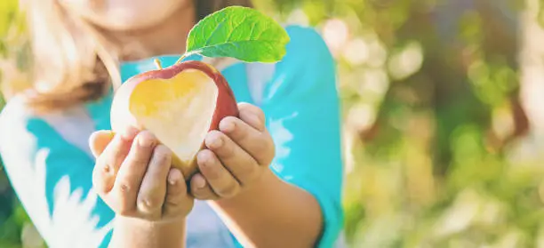 Photo of Child with Child with an apple. Selective focus.