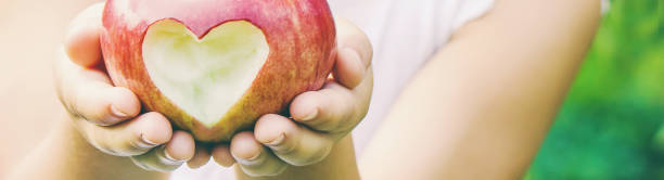 dziecko z dzieckiem z jabłkiem. selektywne skupienie. - apple eating little girls green zdjęcia i obrazy z banku zdjęć