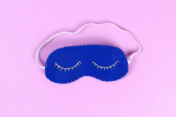 istock Diy blue felt sleep mask with white thread embroidered with closed eyes with eyelashes on gum 1128929185