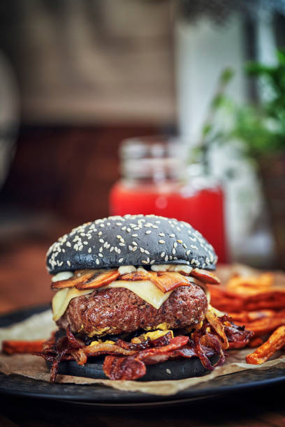 istock Black Burger Buns with Beef Pattie, Cheese, Bacon and Mushrooms 1128930714