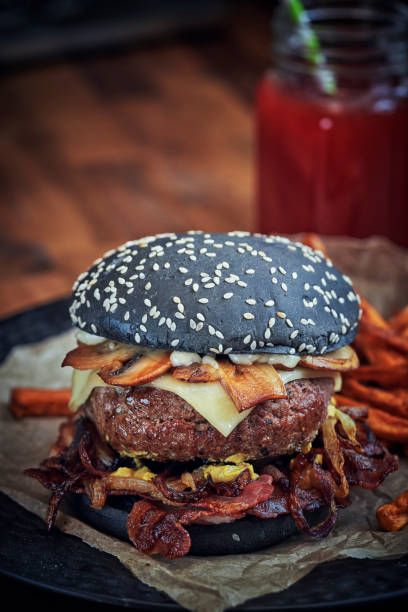 istock Black Burger Buns with Beef Pattie, Cheese, Bacon and Mushrooms 1128930715