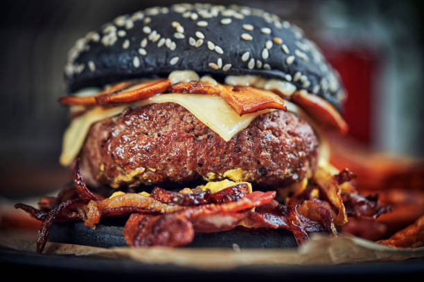 istock Black Burger Buns with Beef Pattie, Cheese, Bacon and Mushrooms 1128930716