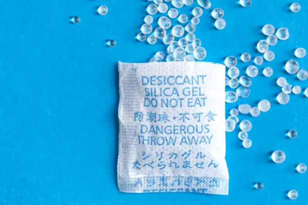 Pouch with Silica gel unfolded on blue background with place for text
