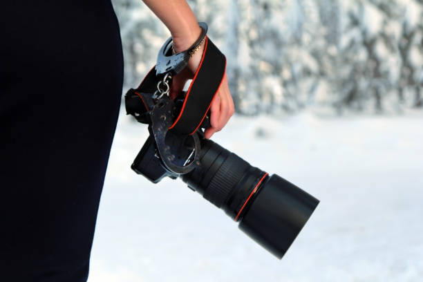 istock Girl with a camera in hand. Fastened with handcuffs. 1128931523