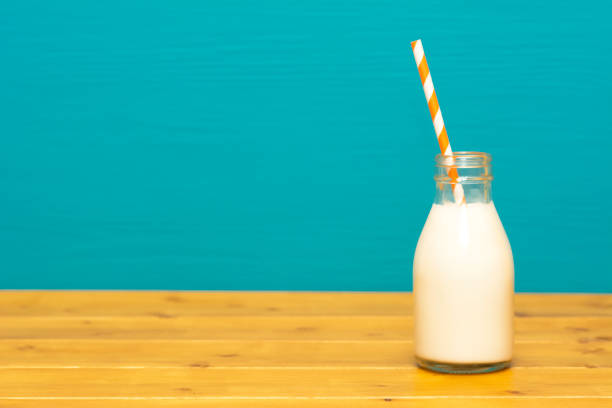 istock Fresh milk with a paper straw in a glass bottle 1128932227