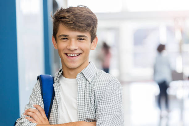 istock Confident teenage boy in high school hallway 1128932865