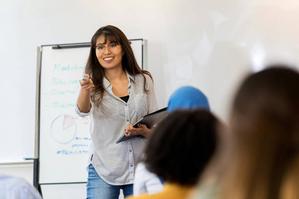 istock Young businesswoman answers training class question 1128933053