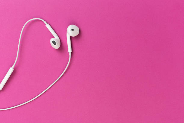 istock white earphones on violet background 1128934047