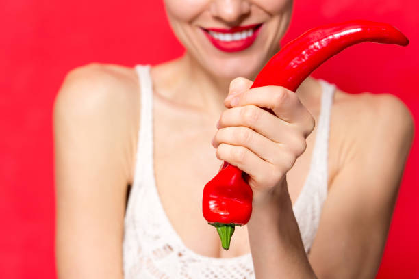 istock young cute woman with red pepper 1128935570
