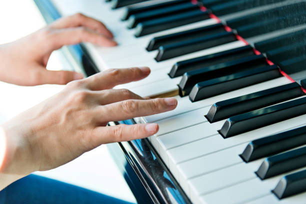 istock Woman hands playing piano 1128936377