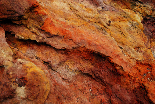 Red, orange, yellow and ocher colours in volcanic rock. This photo was taken on the Etna volcano in Sicily, Italy