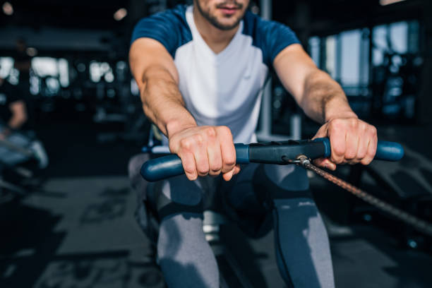istock Cropped image of a muscular man using rowing machine in the gym. 1128944734