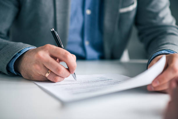 istock Businessman hand signing contract, close-up. 1128944847