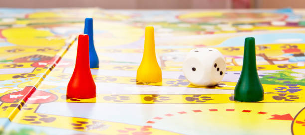istock Board games for the home. Yellow, green and red plastic chips and dice on Board games for children . Selective focus 1128946865