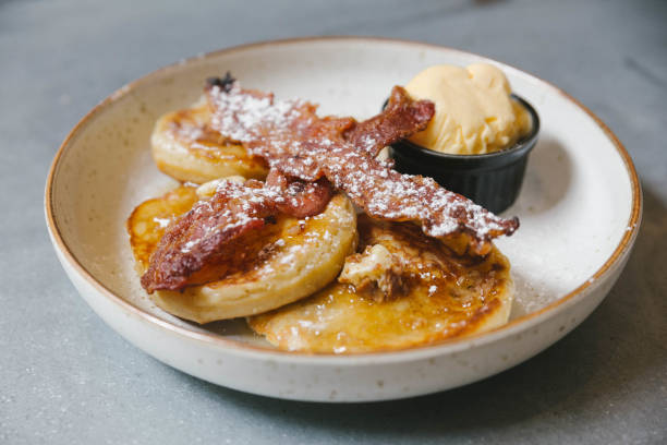 istock Pancakes with butter and maple syrup with Crispy Bacon and Vanilla Ice Cream. Topping with icing. 1128948541