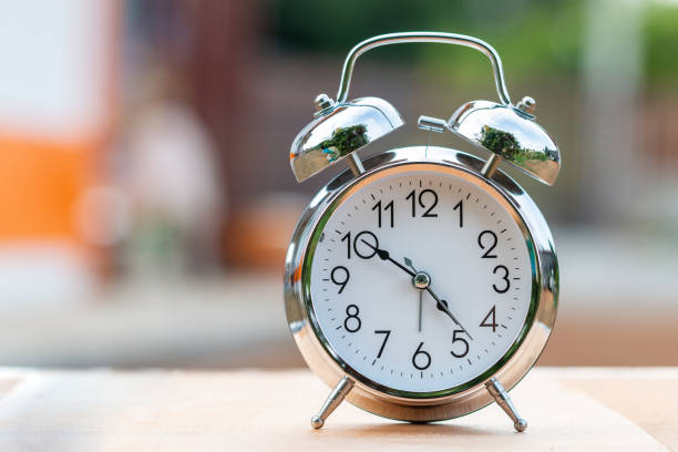istock Retro alarm clock  on wood table 1128949195