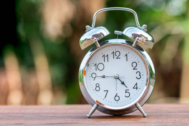istock Retro alarm clock  on wood table 1128949205