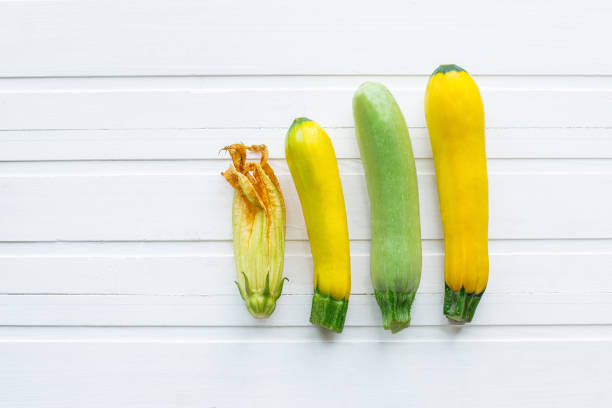 녹색과 노란 호박입니다. 신선한 야채입니다. 흰색 나무 테이블에. 위에서 볼 수 있습니다. - zucchini farm store flower 뉴스 사진 이미지
