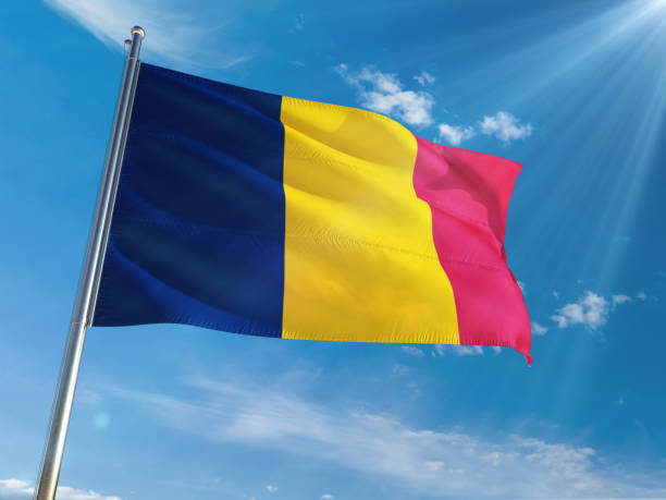 istock Chad National Flag Waving on pole against sunny blue sky background. High Definition 1128954448