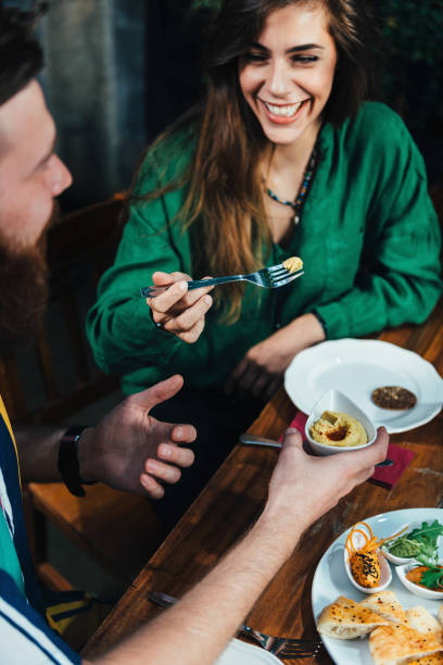 istock Smiling Young Couple Sitting At Table In Restaurant 1128954512