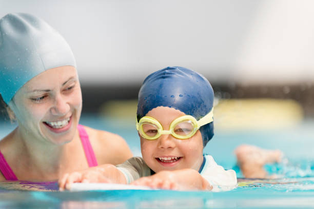 istock Mother Assisting Son In Swimming At Pool 1128954676
