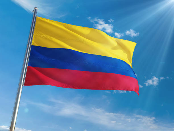 Colombia National Flag Waving on pole against sunny blue sky background. High Definition Colombia National Flag Waving on pole against sunny blue sky background. High Definition national anthem stock pictures, royalty-free photos & images