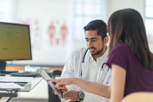 istock Female patient points to her medical chart 1128957510