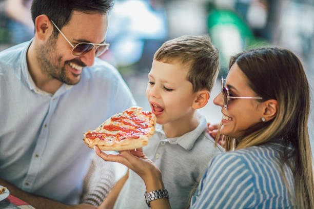 istock Happy family eating in a restaurant 1128958047