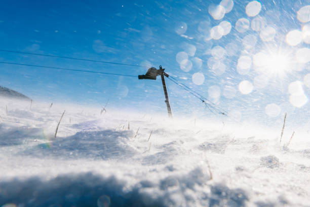 Wind blows snow crystals through the air at abandoned ski slope