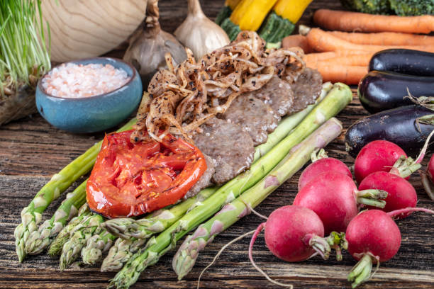 istock Turkish meatballs, (Turkish Food Kofte or Kofta), created background with vegetables, Meatballs on asparagus. 1128959753
