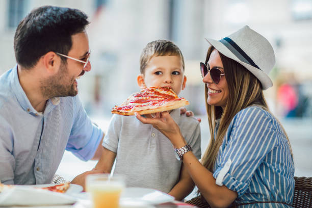 istock Happy family eating in a restaurant 1128960142