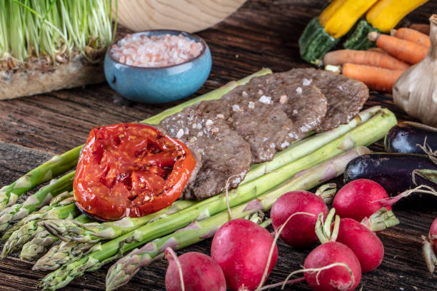 istock Turkish meatballs, (Turkish Food Kofte or Kofta), created background with vegetables, Meatballs on asparagus. 1128961197