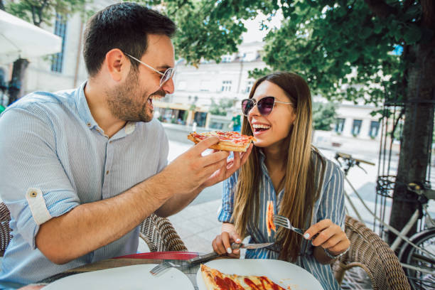 istock Couple eating pizza snack outdoors 1128961584