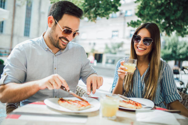 istock Couple eating pizza snack outdoors 1128961642