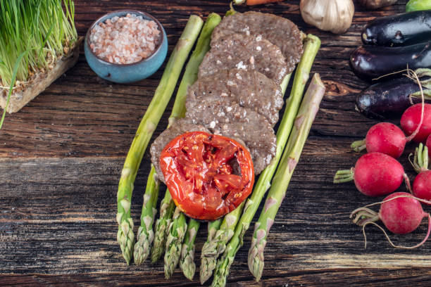 istock Turkish meatballs, (Turkish Food Kofte or Kofta), created background with vegetables, Meatballs on asparagus. 1128962573